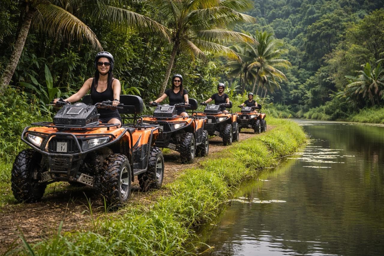 A line of riders on single Gosek Adventure quad bikes following a riverbank track through the jungle in Gianyar, Bali