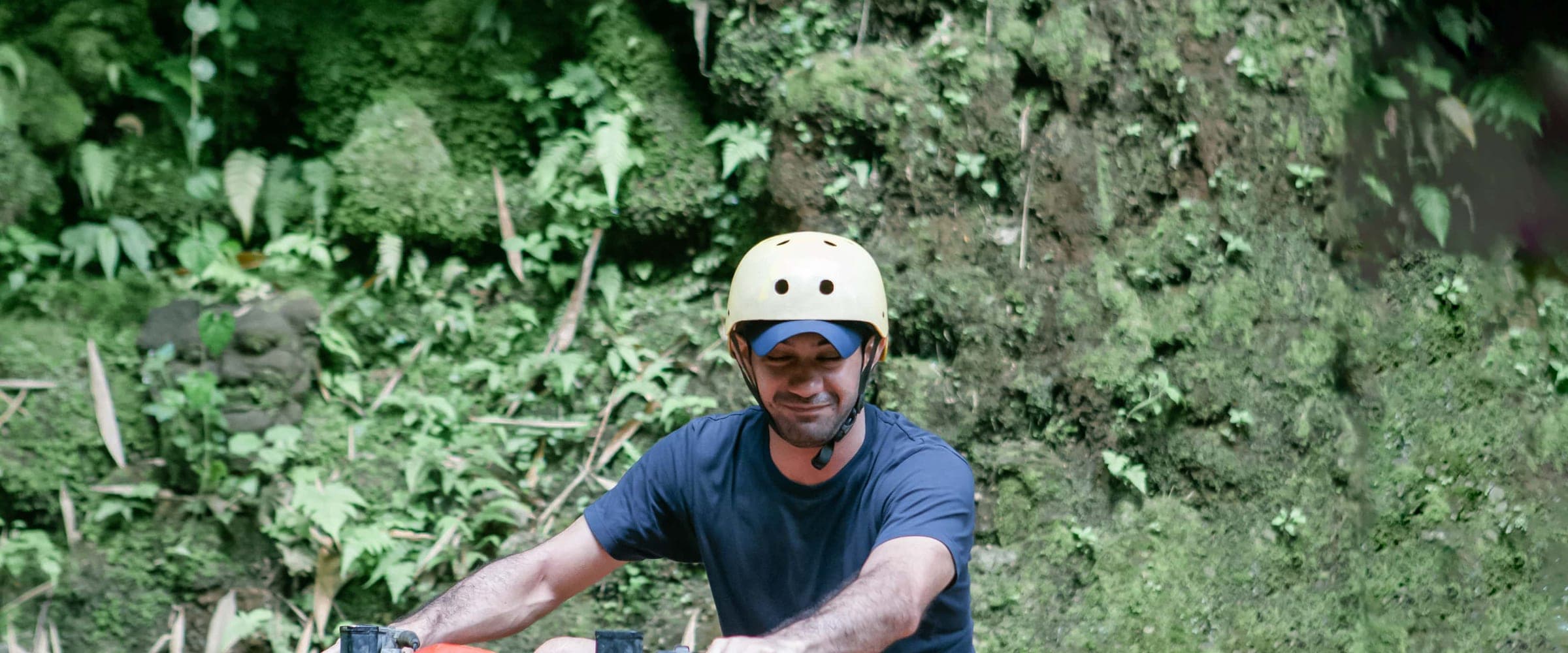 A Gosek Adventure rider on a quad bike against a fern-covered jungle wall on the Temple Run track in Gianyar, Bali